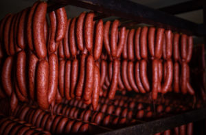 Salmon's Meat Products wieners hanging on a cage in the smoke house